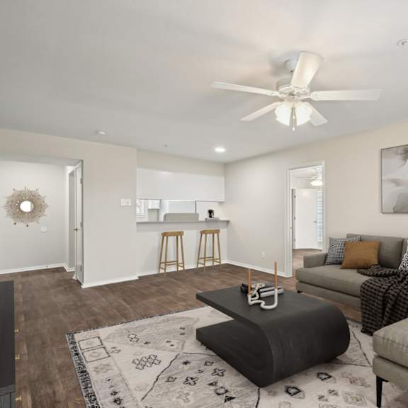 a living room with a couch and a ceiling fan at woodlands of plano in plano, tx
