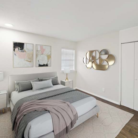 a bedroom with white walls and a bed with grey blankets and pillows at woodlands of plano in plano, tx