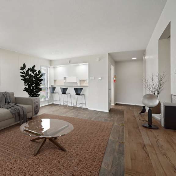 a living room with a couch and a table at woodlands of plano in plano, tx