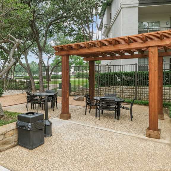 a patio area for al fresco dining with tables and chairs at jefferson place apartments in irving, tx