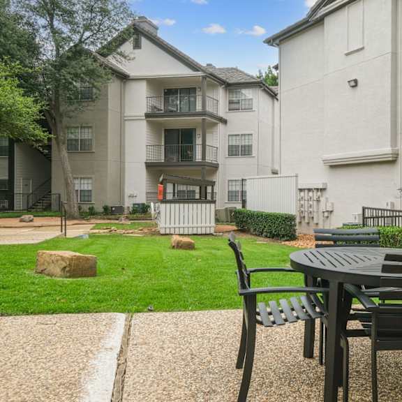 al fresco dining table with apartment buildings in the back at jefferson place apartments in irving, tx