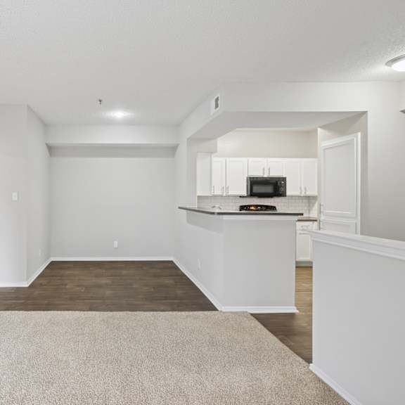 b2 living room with a kitchenette in the background at jefferson place apartments in irving, tx