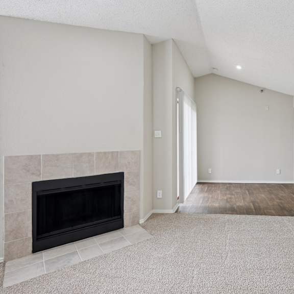 b2 carpeted living room with white walls and a fireplace at jefferson place apartments in irving, tx