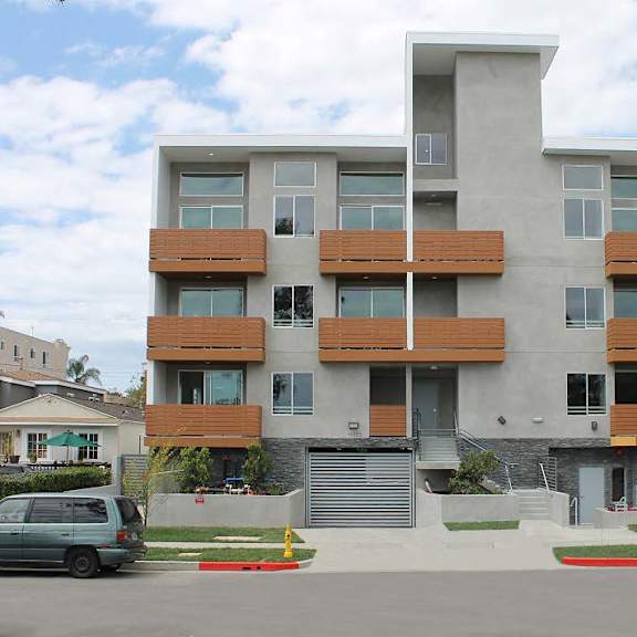 a modern apartment building with a mix of white and brown balconies.