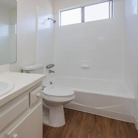 a white bathroom with a toilet, sink, and bathtub.