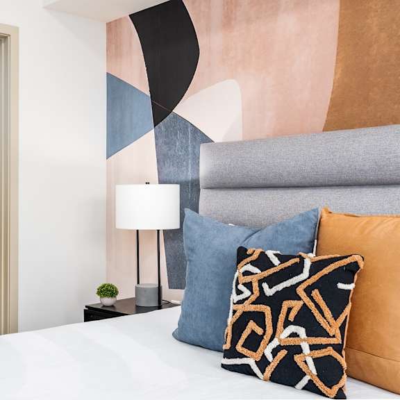 bedroom with colorful geometric wall mural at lido - 1532 brockton ave apartments, los angeles, ca