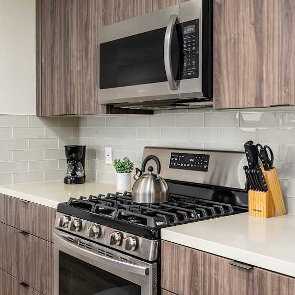 modern kitchen with gas range and subway tile backsplash at lido - 1532 brockton ave apartments, los angeles, ca