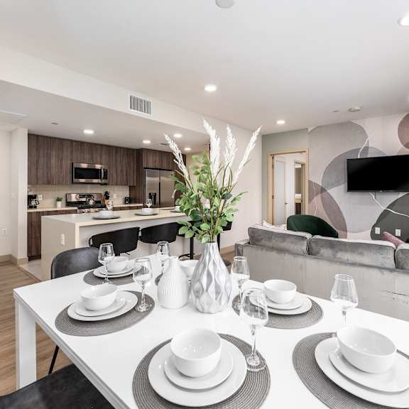 dining room with modern table setting and kitchen view at lido - 1532 brockton ave apartments, los angeles
