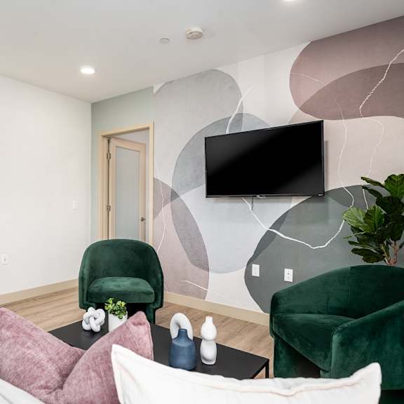 contemporary living room with emerald green chairs at lido - 1532 brockton ave apartments, los angeles, ca 90025