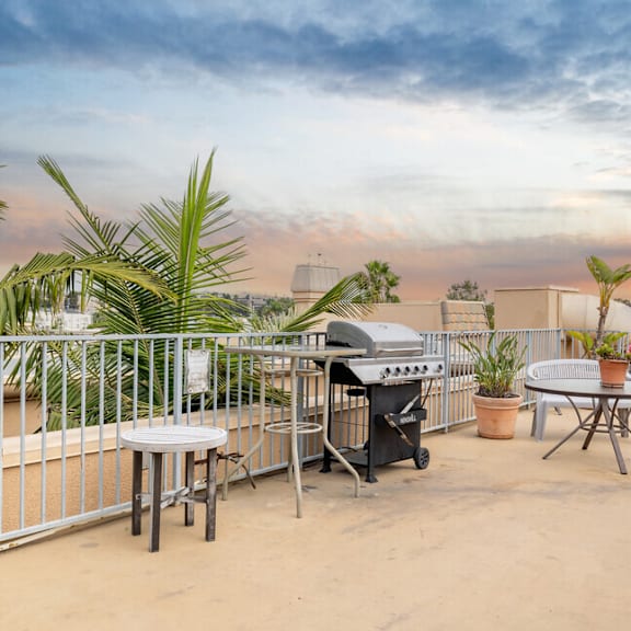 the patio has a bbq grill and a table and chairs
