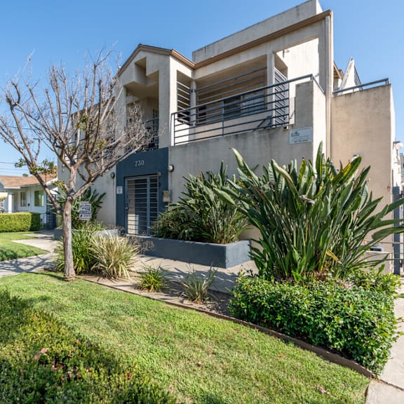 the front of a house with a yard and a sidewalk