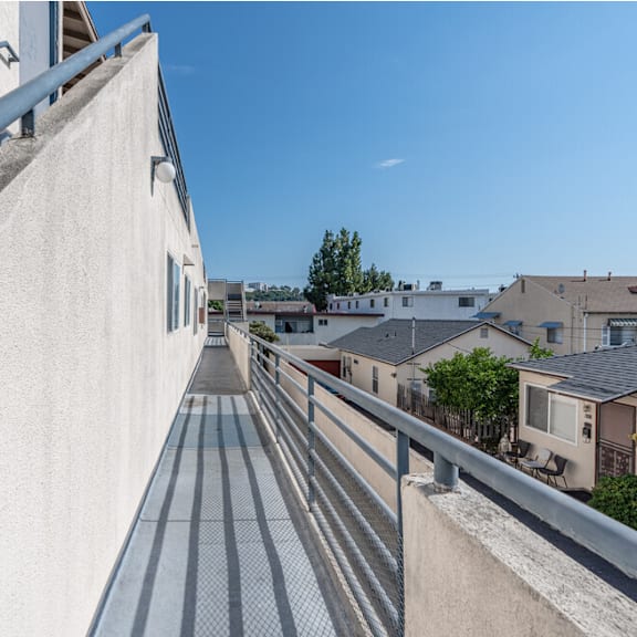 the side of a building with a balcony and a blue sky