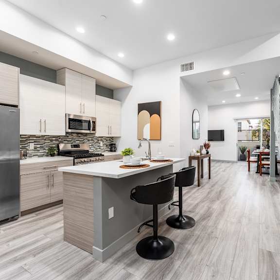 a kitchen with a counter top and a staircase at lido apartments - 4025 grandview, california, 90066