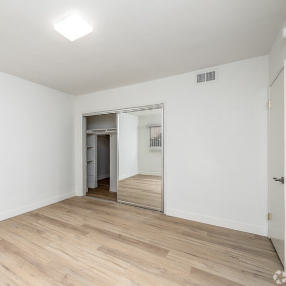 an empty living room with white walls and wood floors