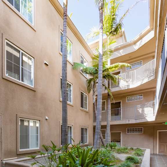 a building with a balcony and a tree in front of it.