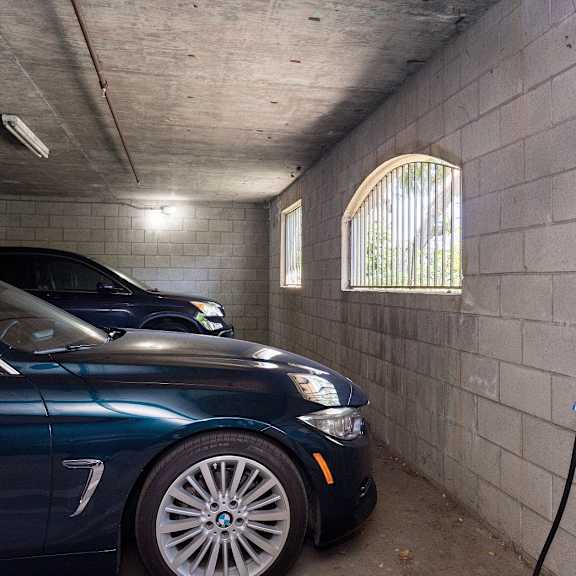 a blue car is parked in a parking garage and charging its battery.