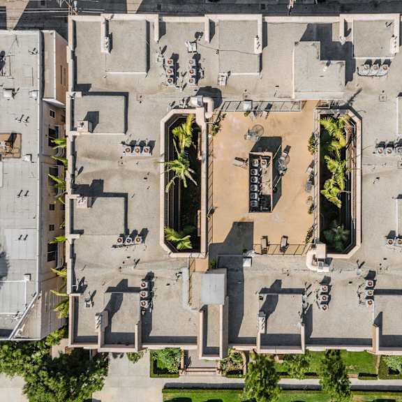 a courtyard surrounded by buildings with a fountain in the middle.