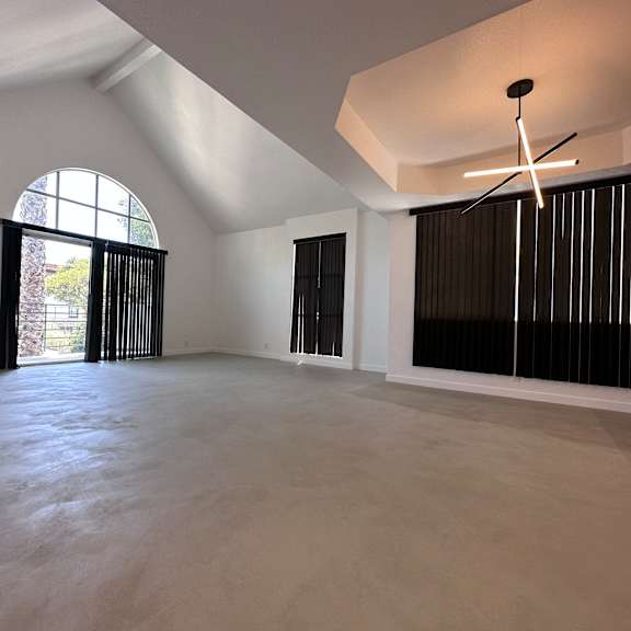 a large, empty room with a fireplace and a large window.