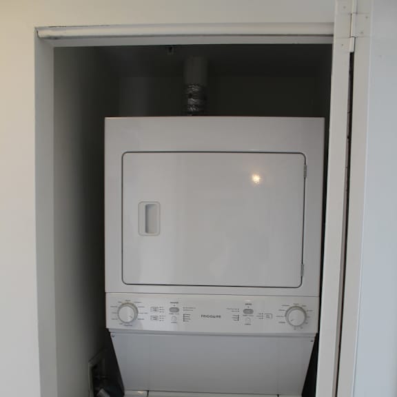 a white dryer is in a white doorway.
