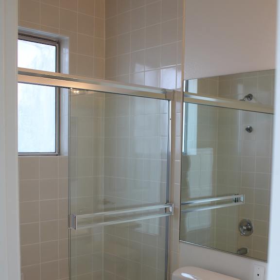 a white toilet in a bathroom with a glass shower door.