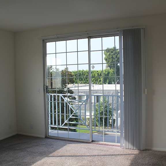 a room with a sliding glass door leading to a balcony.