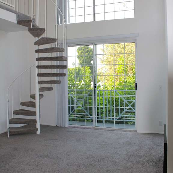 a white spiral staircase with a metal railing.