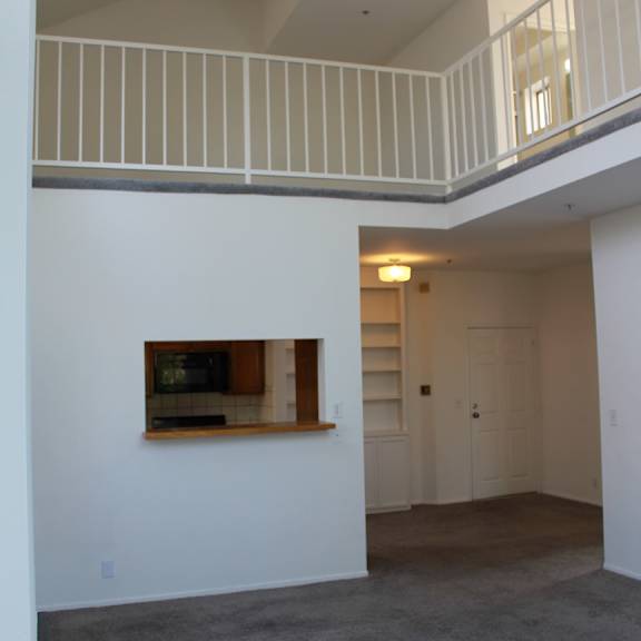 a room with a grey carpet and a painting on the wall.
