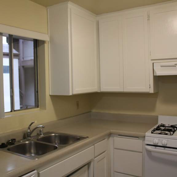 a kitchen with white cabinets and a stove.