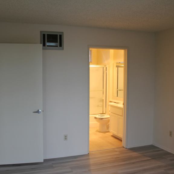 a bathroom with a toilet and sink is visible through an open door.