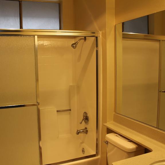 a bathroom with a toilet, sink, and shower.