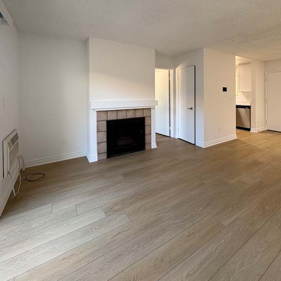 a room with a fireplace and wooden floors.