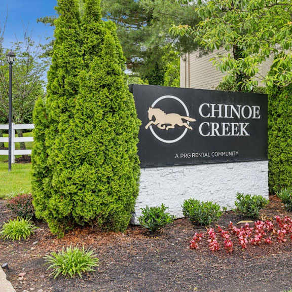 a sign for chinook creek in front of a white fence at chinoe creek apartments, kentucky, 40502