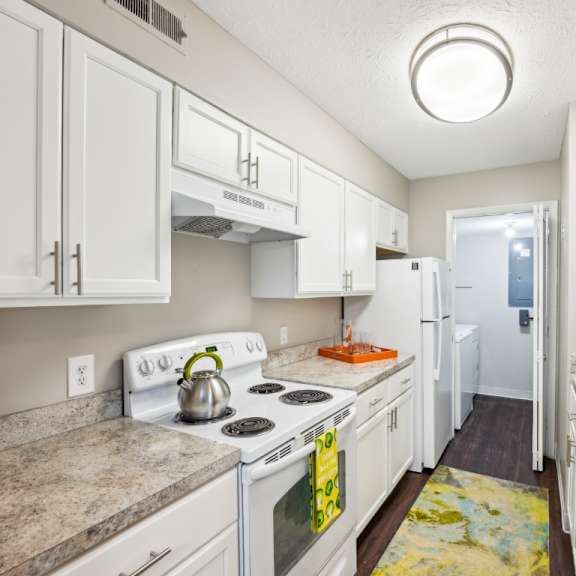 a kitchen with white cabinets and a stove top oven at chinoe creek apartments, lexington 40502