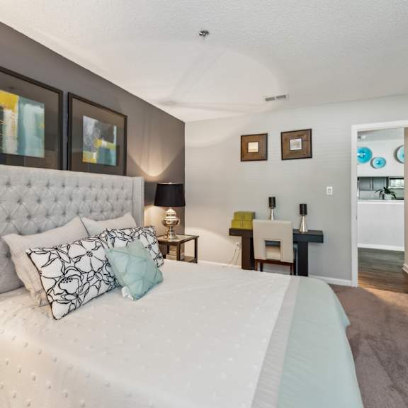 a bedroom with a large bed and a white headboard. at the timbers apartments, richmond