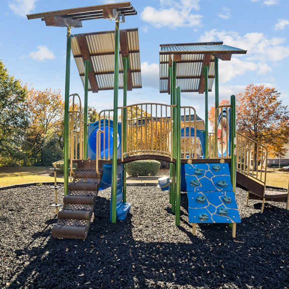 a playground with a blue slide and a brown wooden structure at lakecrest apartments, prg real estate management, greenville, sc, 29615