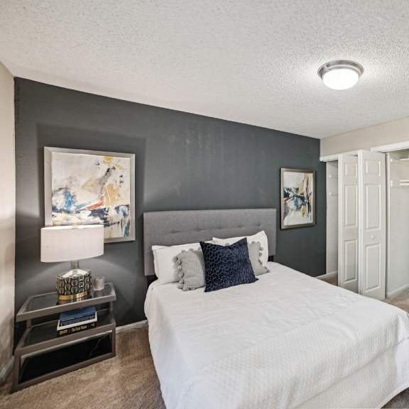 a bedroom with a large bed and a painting on the wall at willow ridge apartments, north carolina, 28210