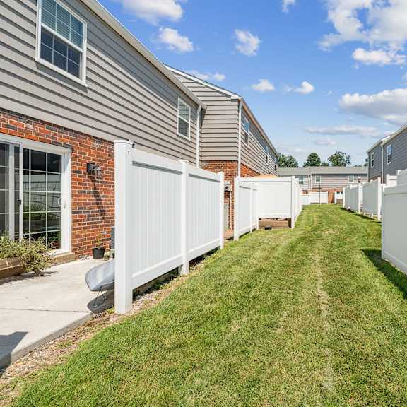 a row of houses with white fences in front at staples mill townhomes apartments, richmond, va
