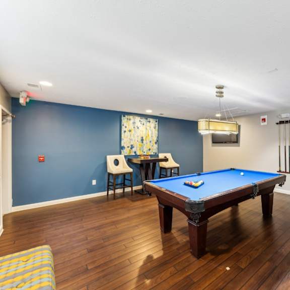 a pool table in a room with blue walls at chinoe creek apartments, lexington, ky, 40502