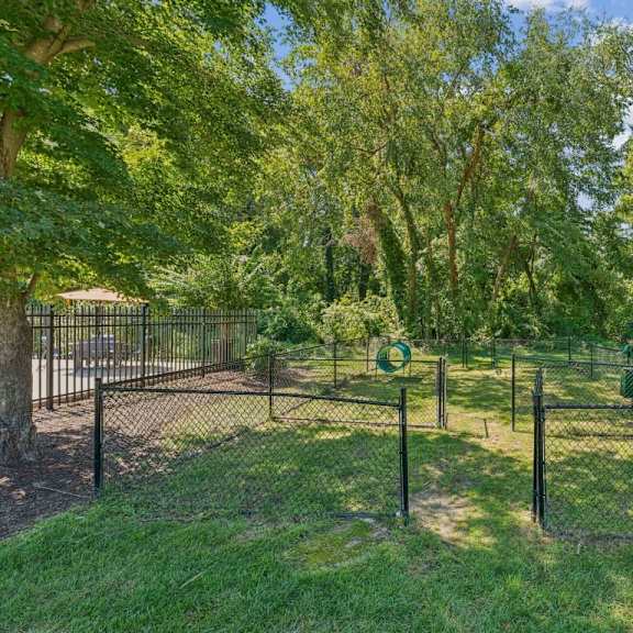 a park with a green bench and a fence at staples mill townhomes apartments, richmond