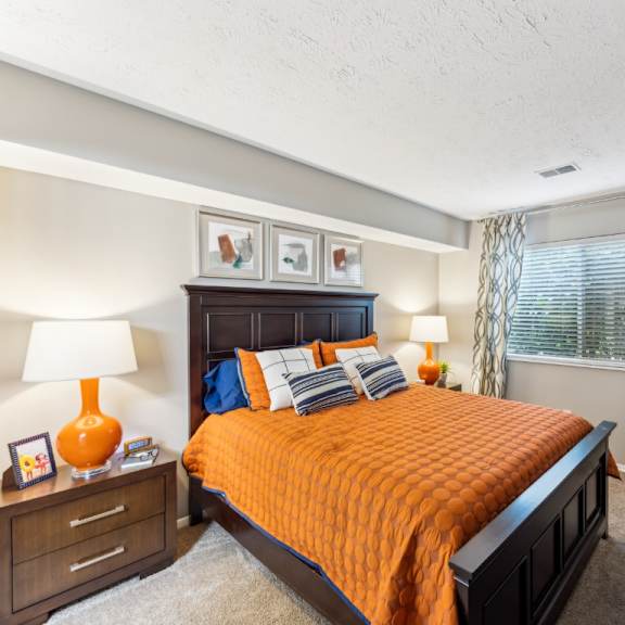 a bedroom with a bed, nightstand, and window at chinoe creek apartments, lexington 40502