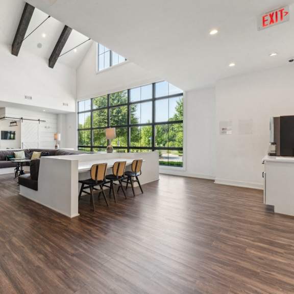 a living room with a kitchen and a dining area with a large window at beckett farms apartments, prg real estate management, fort mill, 29715