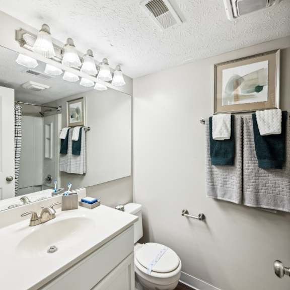 a white bathroom with a toilet, sink, and towel rack at chinoe creek apartments, lexington, kentucky