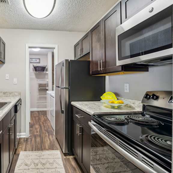 a kitchen with black appliances and a marble countertop. at the timbers apartments, richmond 23235