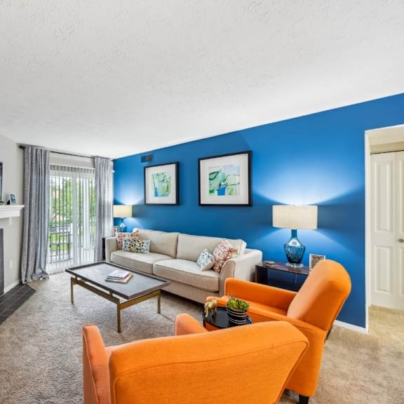 a living room with a fireplace, a couch, a chair, and a television at chinoe creek apartments, lexington, ky