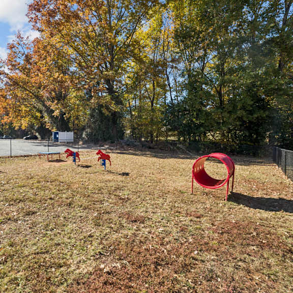a playground with a red tunnel and two children playing at lakecrest apartments, prg real estate management, greenville, sc, 29615