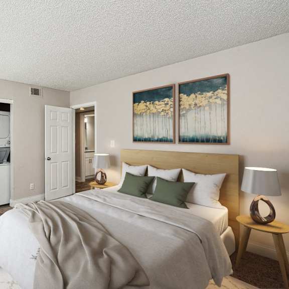 a bedroom with a large bed and two paintings on the wall at the reserve at barry apartments, kansas city, mo
