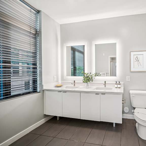 a white bathroom with a toilet, sink, and shower. at the locks tower, richmond, virginia