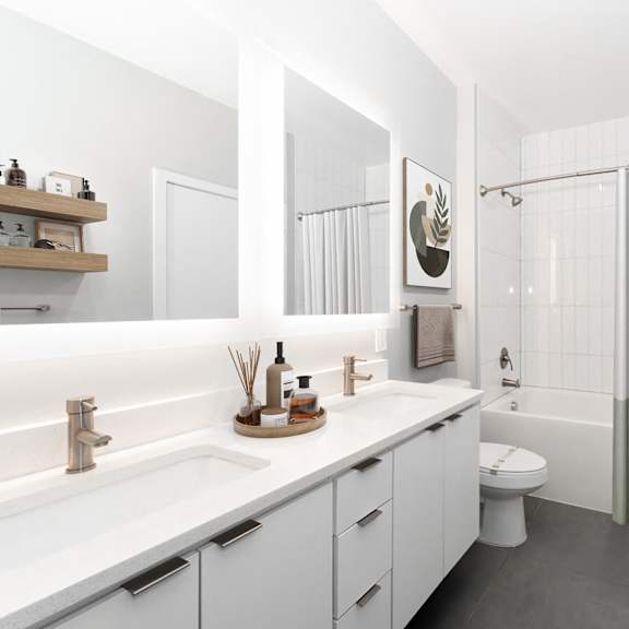 a white bathroom with a toilet, sink, and shower. at the locks tower, richmond