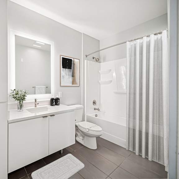 a white bathroom with a toilet, sink, and shower. at the locks tower, virginia, 23219