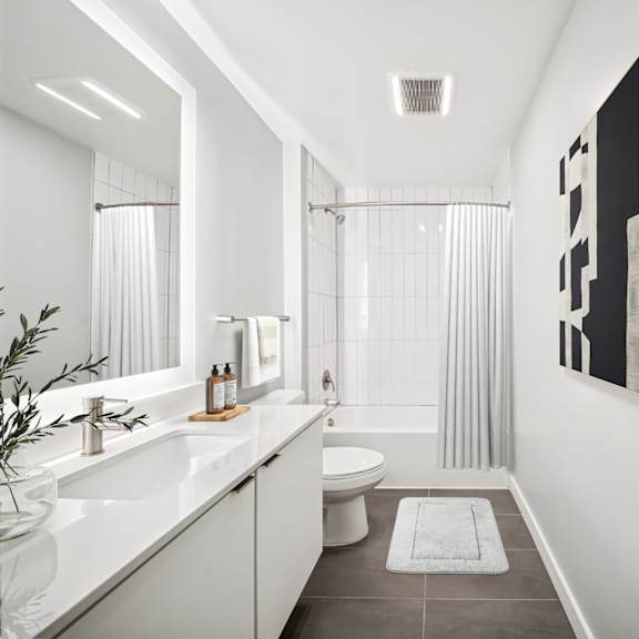 a bathroom with a white sink, toilet, and bathtub with a grey floor and a white wall. at the locks tower, richmond, 23219